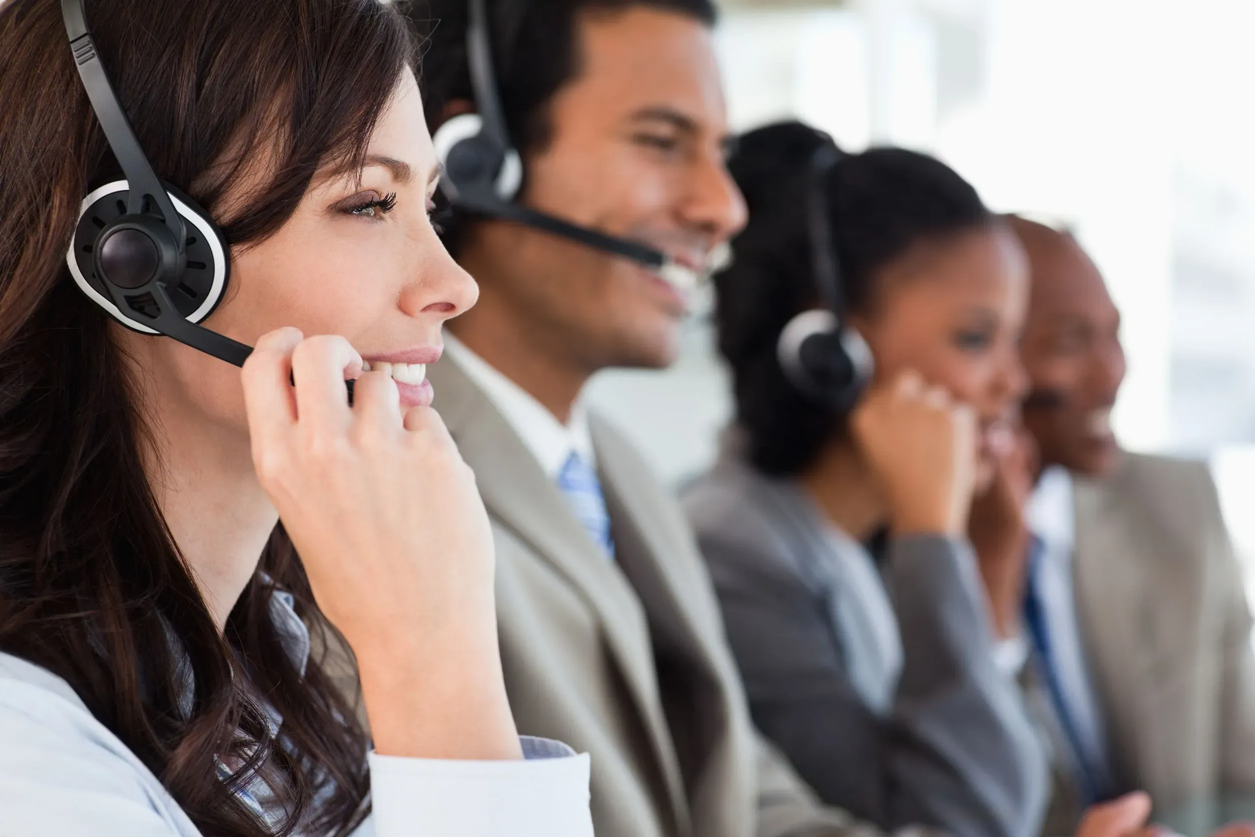 A row of customer service agents working at a contact center
