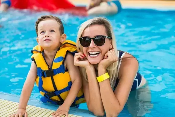 A parent and child enjoying a pool, representing the customer outcome of a well-staffed process