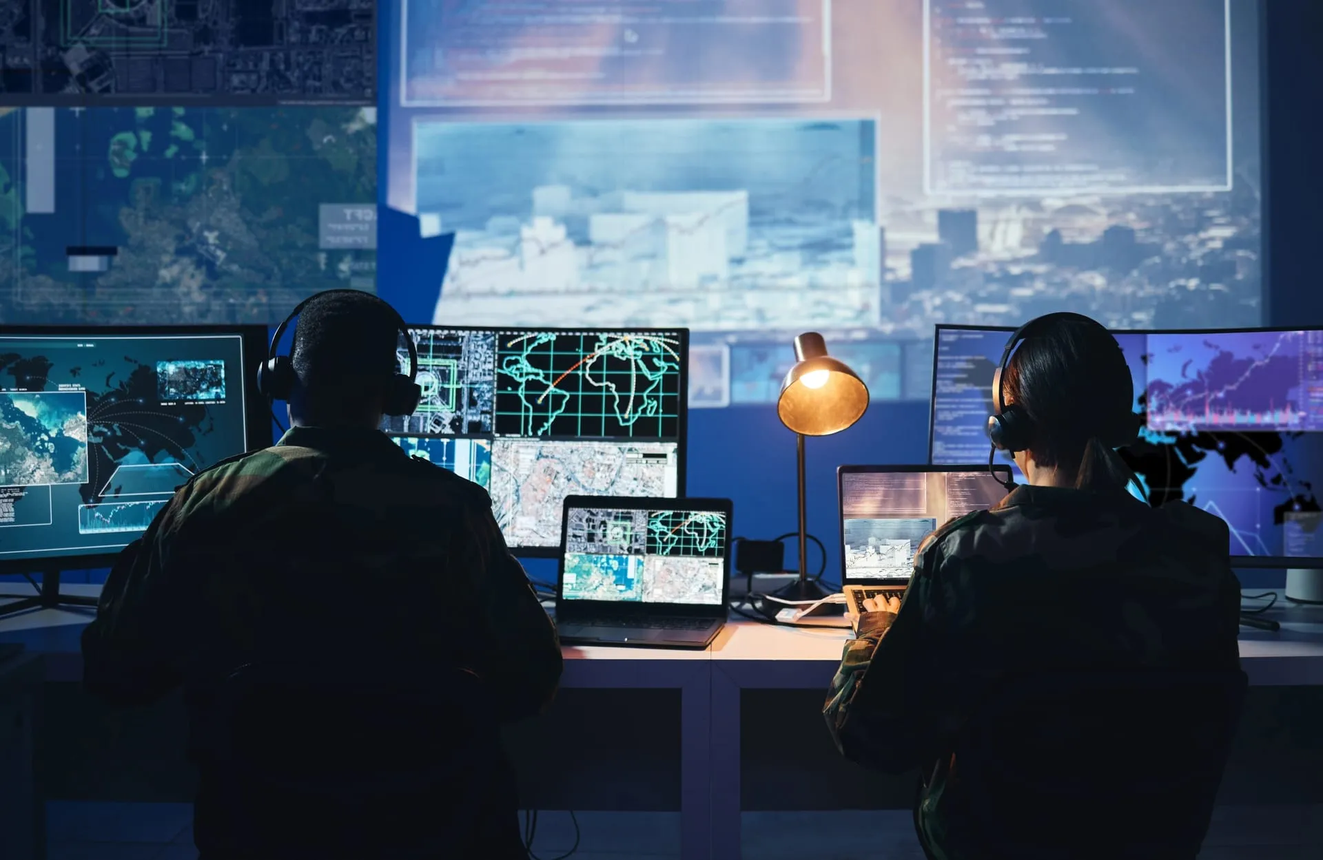 Defense analysts reviewing intelligence data at a multi-screen analysis station